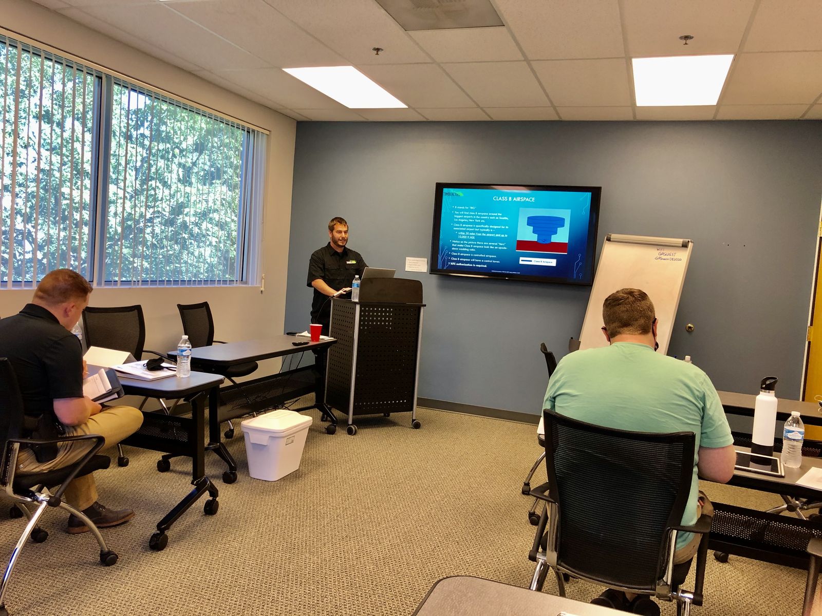 A Quantum Dynamics instructor teaching Class B airspace from the front of a Part 107 classroom