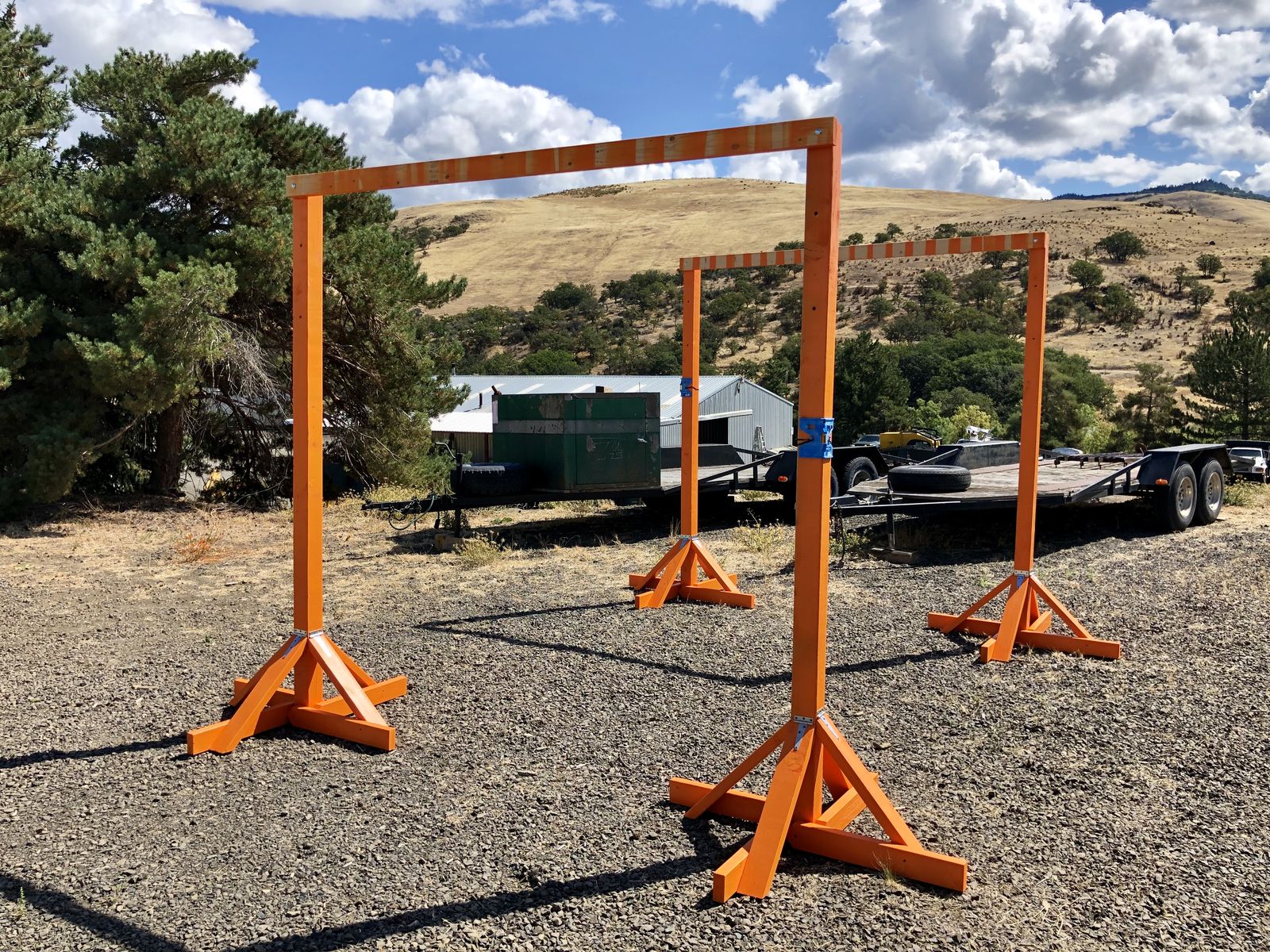 Orange NIST course gates standing on the Quantum Dynamics practical training ground, hills behind